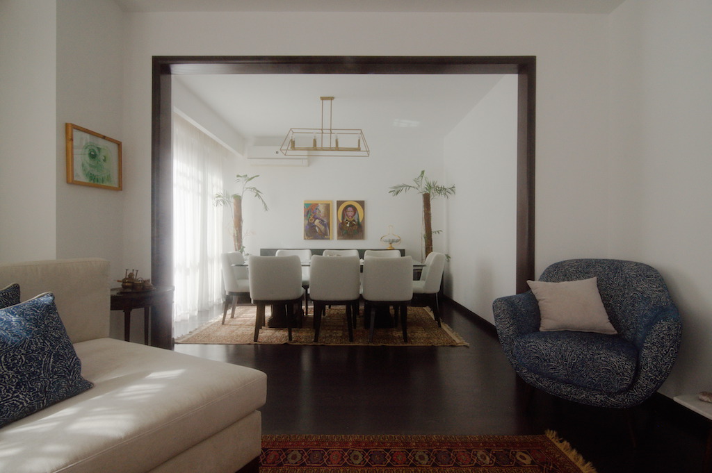 Minimalist dining space with warm wood tones and curated furniture in luxury duplex renovation