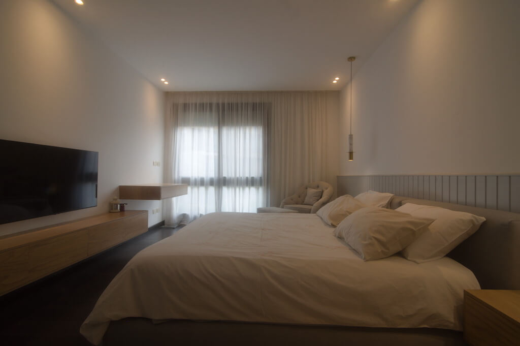 Master bedroom with soft neutral tones, minimalist furniture, and layered textures in Sodic Westown duplex renovation