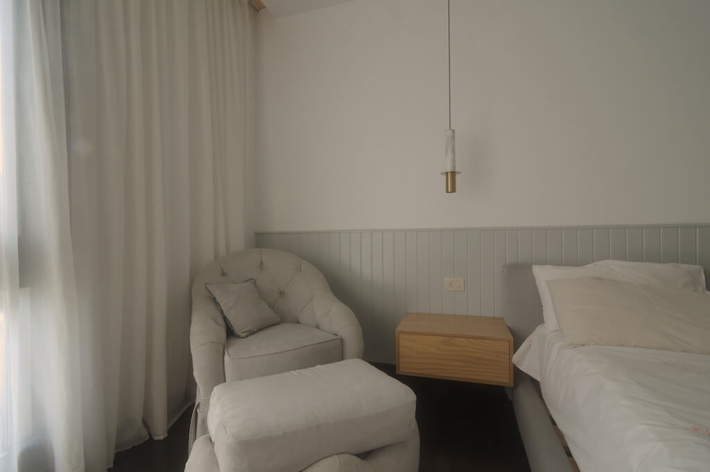 Master bedroom with soft neutral tones, minimalist furniture, and layered textures in Sodic Westown duplex renovation