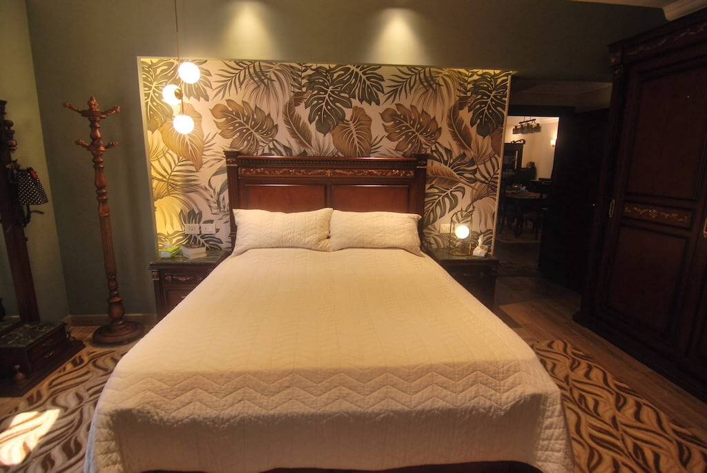 Soft-toned bedroom with rustic finishes and ambient lighting in New Cairo apartment