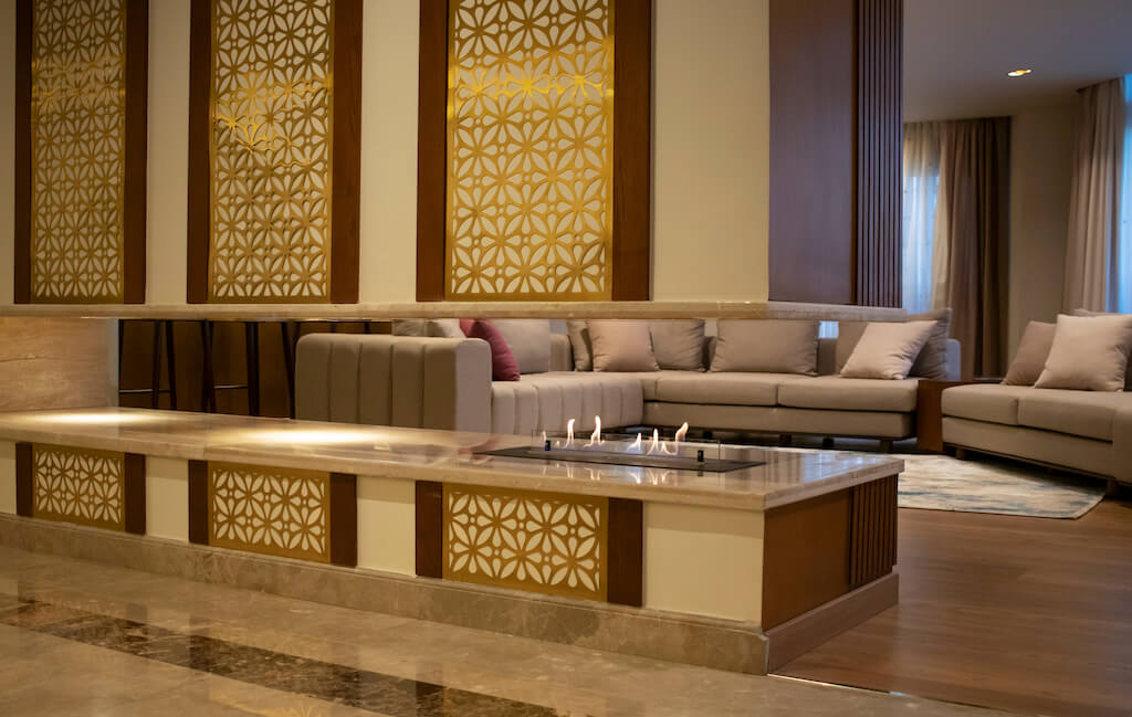 Custom-built partition with integrated fireplace and textured finishes in luxury Heliopolis flat design and build