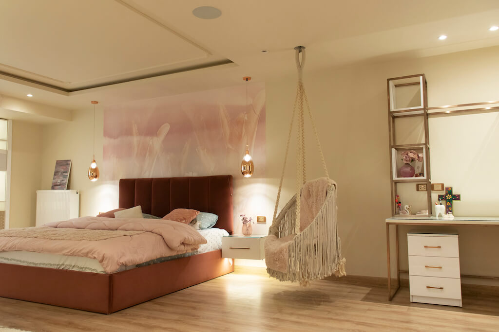 Master bedroom featuring layered lighting, soft wall finishes, and relaxing swing