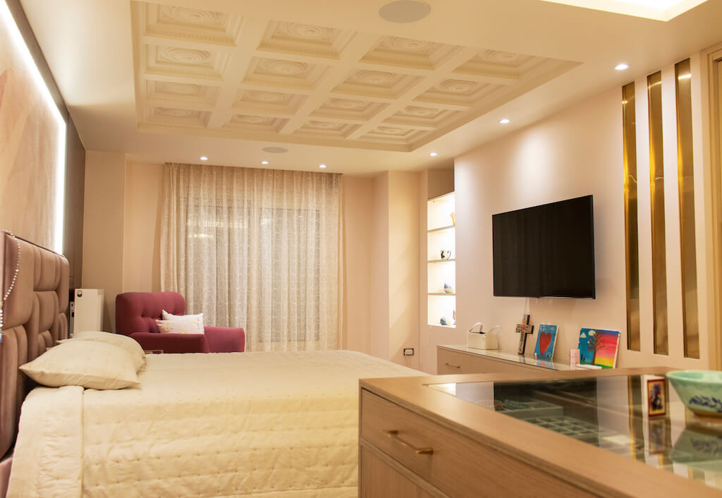 Master bedroom featuring ornate ceiling lighting, soft wall finishes, and smart climate control in a turnkey interior