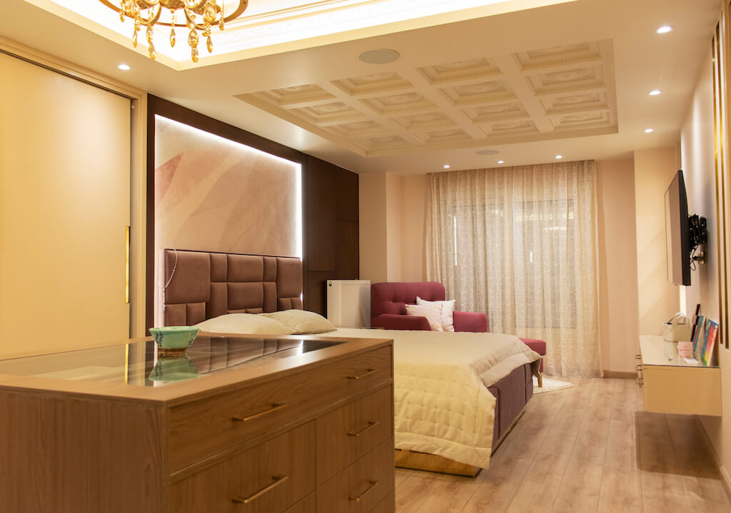 Master bedroom featuring ornate ceiling lighting, soft wall finishes, and smart climate control in a turnkey interior