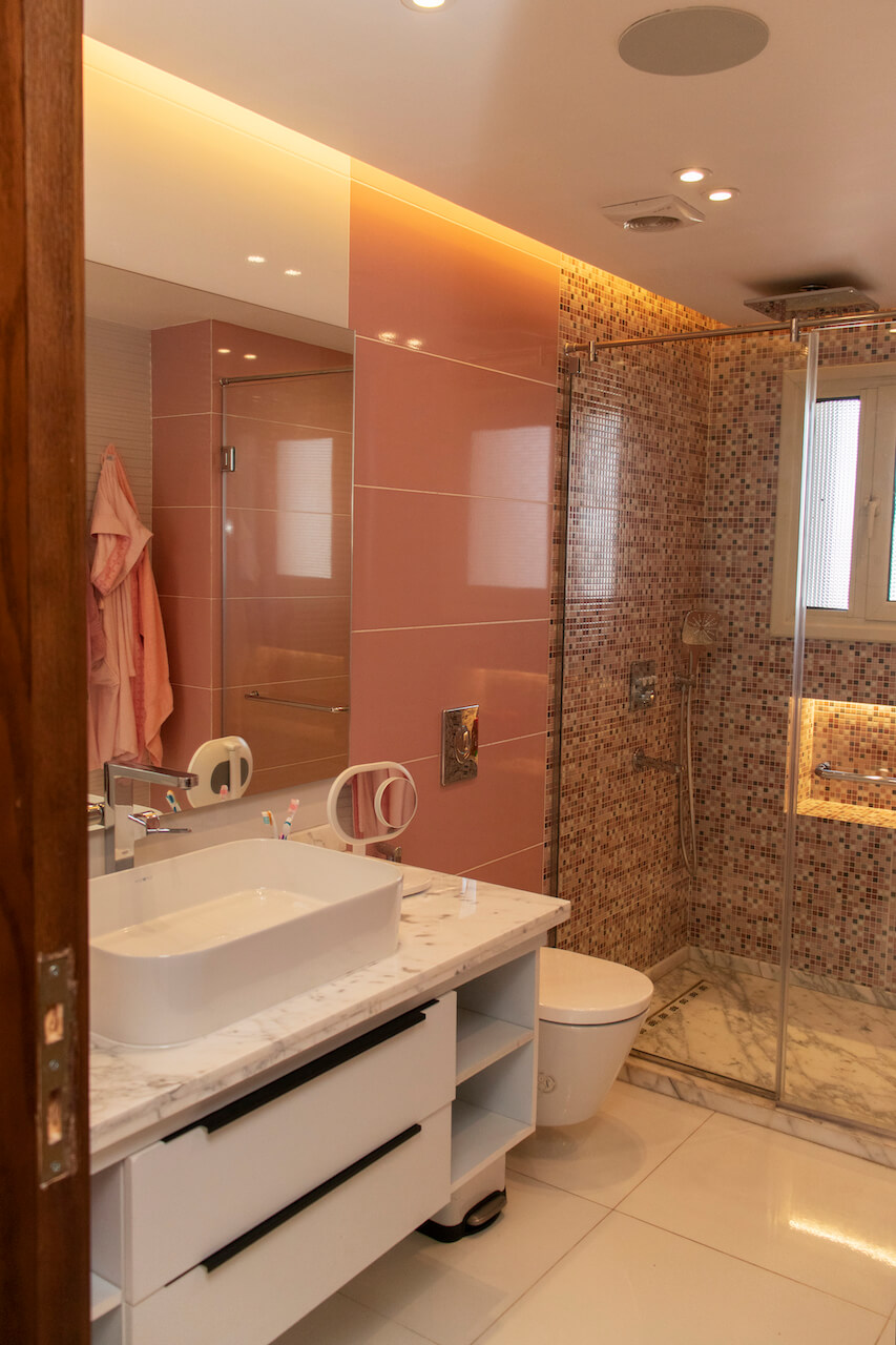 Vibrant bathroom design with colorful pink tiles and built-in lighting in turnkey Heliopolis flat