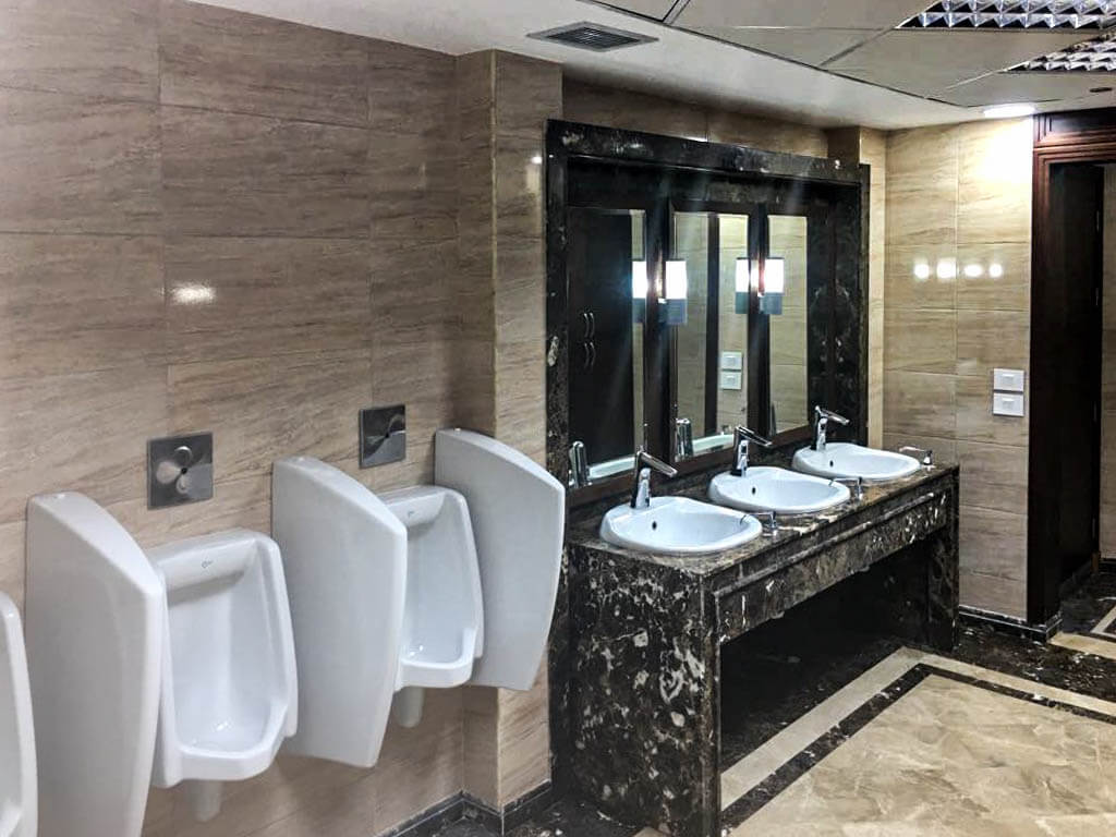 Refinished bathroom stalls with updated materials in commercial office space in Cairo