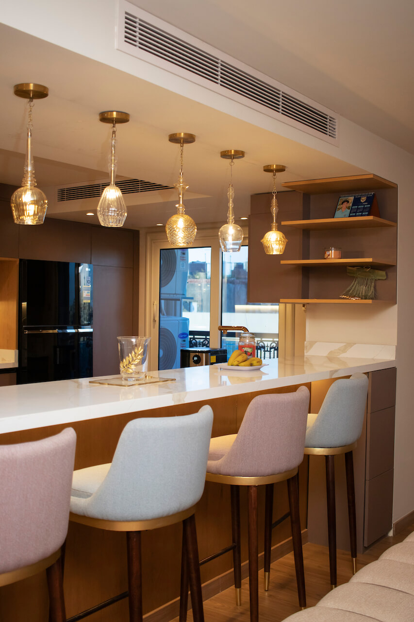 Modern kitchen bar with glass pendant lighting in a turnkey Heliopolis flat