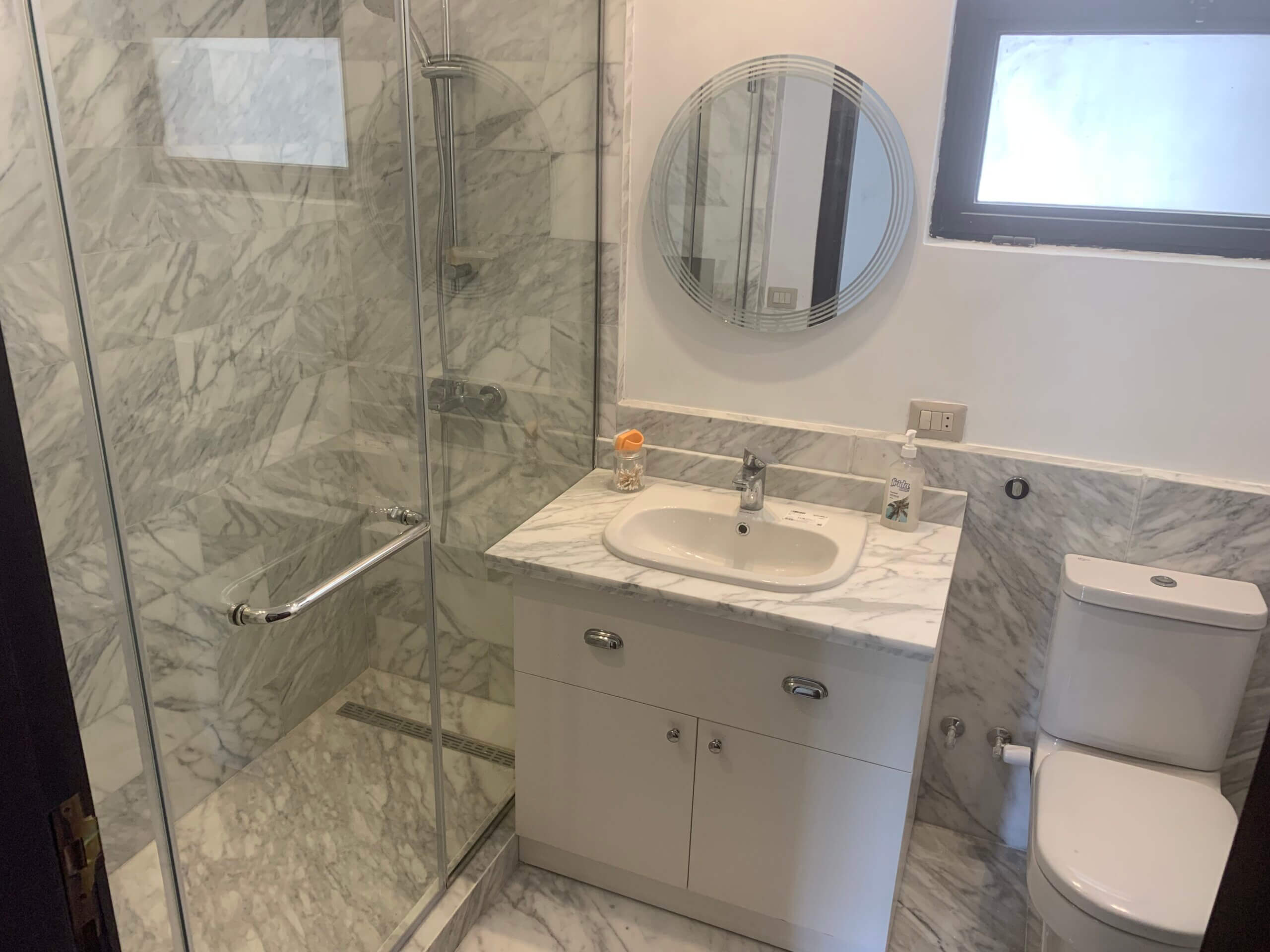 Renovated master bathroom with sleek marble tile work in Westown duplex project