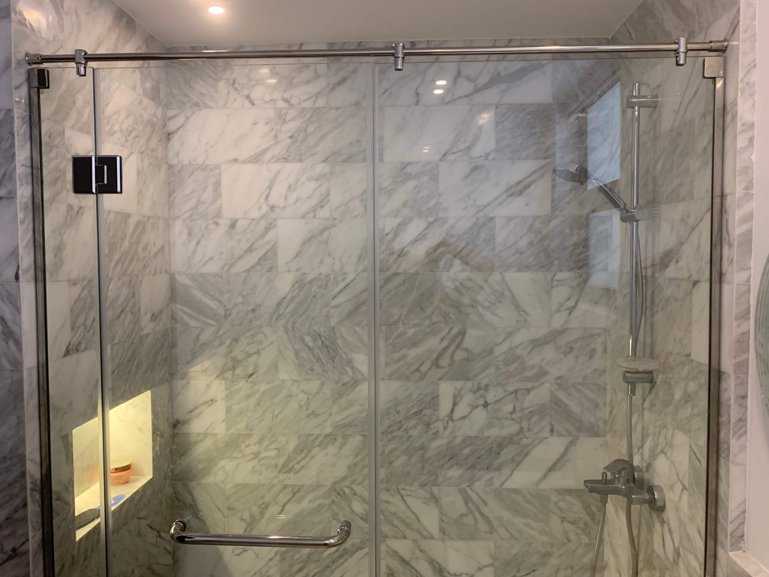 Renovated master bathroom with sleek marble tile work in Westown duplex project