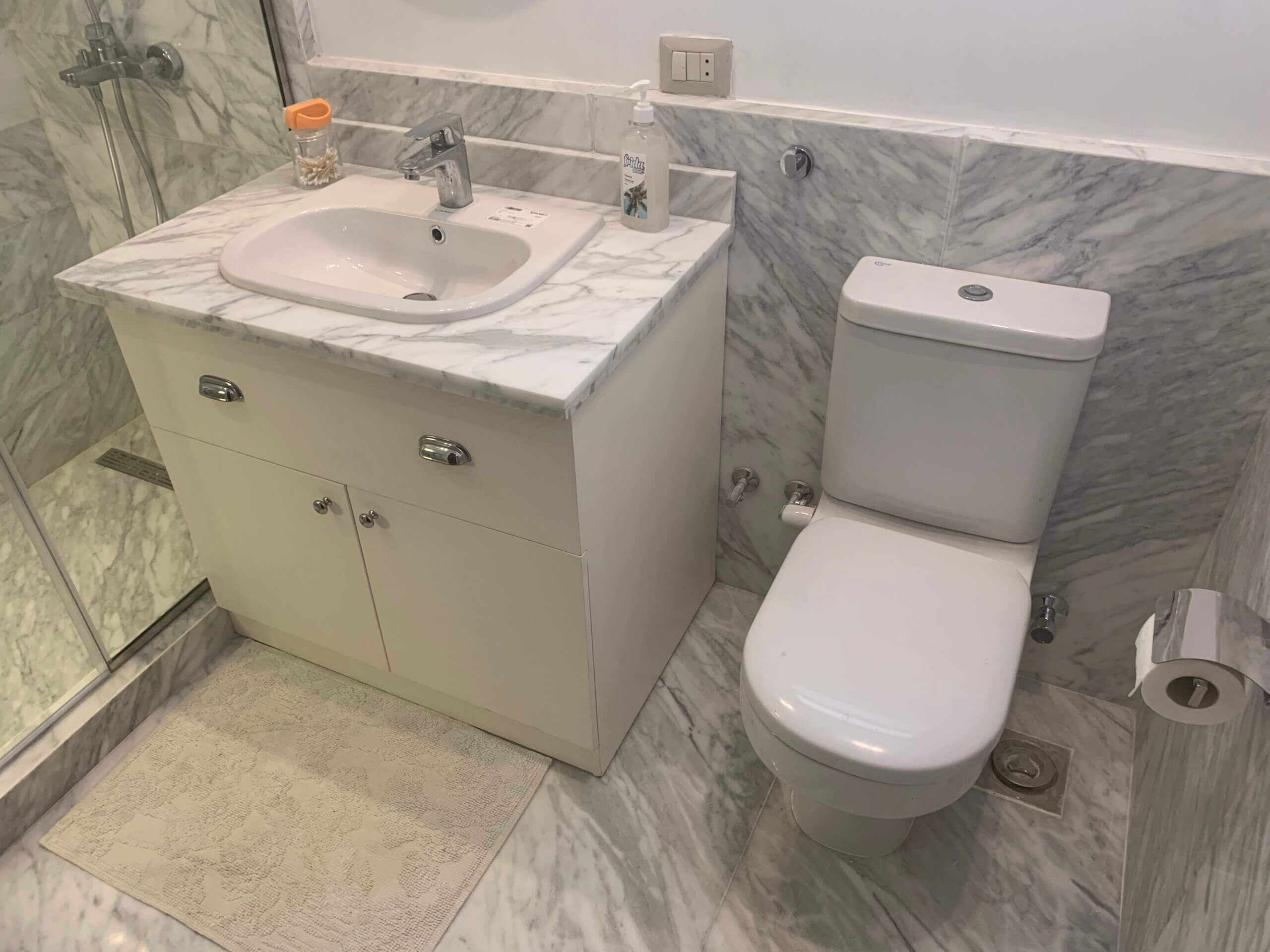 Renovated master bathroom with sleek marble tile work in Westown duplex project
