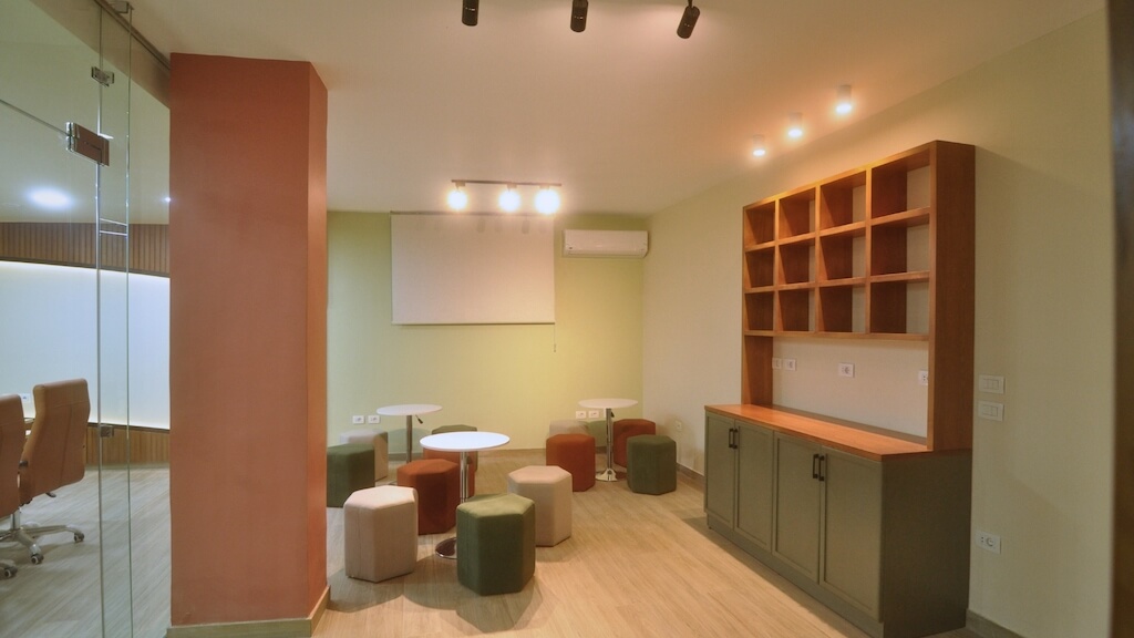 Coffee break area with bar counter and casual seating in corporate training space in New Cairo


